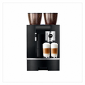A black Jura Giga 8 coffee machine with two dark brown coffee bean hopper containers on top, shown with two glasses of layered latte macchiato below the dispensing spout, on a plain white background.
